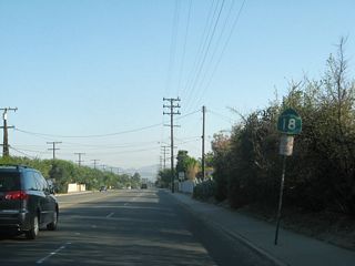 A California 18 reassurance shield is posted after Parkdale Drive along southbound Waterman Avenue.