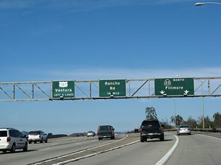 Northbound U.S. 101 (Ventura Freeway) reaches Exit 43A, California 23 (Moorpark Freeway) north. Again note the variation in pavement color to differentiate through traffic from exit lanes. Also notice that the entire U.S. 101 through traffic sign has been overlaid with a new shield, control city, and number of lanes for through traffic.