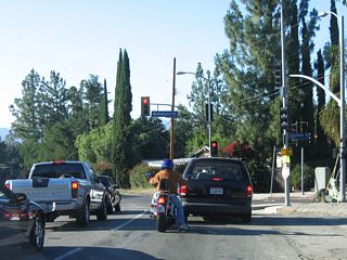 Northbound California 27 meets Mulholland Drive at this signalized intersection.