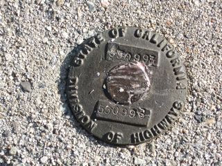 This California Division of Highways marker is embedded in poured concrete at the top of a retaining wall that dates to the original construction of San Gabriel Canyon Road. It is located just south of the closed section of California 39, near Crystal Lake.