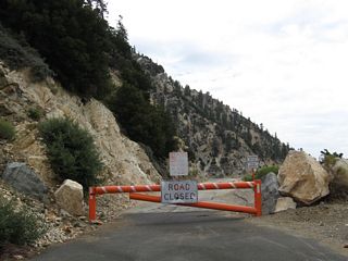 A barricade blocks vehicular entry onto the abandoned section of California State Route 39.