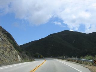 Passing through Los Padres National Forest, SR 41 navigates through several sharp turns, with a steep slope alongside portions of the roadway.