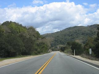 A roadside paddle (postmile marker) along eastbound California 41 (E.G. Lewis Highway) indicates the distance traveled since the route began in Morro Bay: 12 miles.