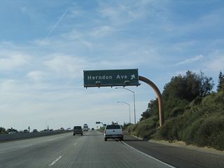 Northbound California 41 (Eisenhower / Yosemite Freeway) reaches Exit 134, Herndon Avenue. Ahead, the section of California 41 freeway between Herndon Avenue and Audubon Drive was built in 1988-1989.