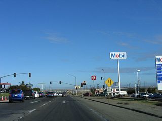 Northbound California 41 approaches Bernard Drive at the next traffic signal; this signal aids traffic flow into the gas stations and restaurants nearby.