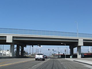 The viaduct taking SR 1 (Pacific Coast Highway) over Alameda Street was built in 2004 as part of the Alameda Corridor project. A service road named Pacific Coast Highway spurs east below the elevated roadway from a signalized intersection with SR 47.