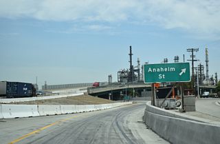 Lowering to grade level, northbound SR 47 (Henry Ford Avenue) continues with two lanes below the Terminal Island Freeway to the signalized intersection with Pier A Avenue east and Anchorage Road south.