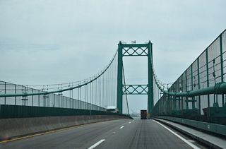 The suspension bridge is named for former State Assemblyman Vincent Thomas, a legislator who championed the bridge's construction and was present to open the crossing to traffic in 1963. The bridge was constructed at a time when the Port of Los Angeles and Port of Long Beach were still growing and gaining traffic volume, so its importance grew as it served more trucks and commercial traffic associated with the port.
