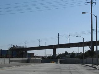 SR 47 (Alameda Street) diverges from parallel Compton Creek below the Metro Blue Line, a light rail line between Downtown Los Angeles and Long Beach north of the convention center.
