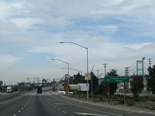 A ground level sign posted at the Exit 1 B gore point once displayed the toll rates for the Vincent Thomas Bridge. Toll collection ceased in 2000.