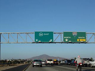 The right two lanes connect to Interstate 805; the right lane becomes exit only for Interstate 805 (Dekema Freeway) south to Chula Vista and the International Border. To the north, Interstate 805 travels toward North Park, Mission Valley, Serra Mesa, Clairemont Mesa, and Sorrento Valley.