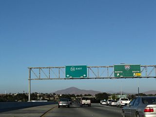 Eastbound California 54 (Filipino-American Highway) reaches Exit 2, Interstate 805. The left three lanes continue east on California 54; the through lanes were reconfigured to accommodate more traffic in 2008.