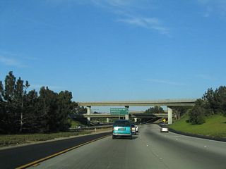 Eastbound California 54 approaches the Interstate 805 overpass and interchange. Traffic will merge into California 54 from the right.