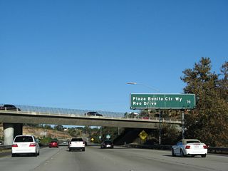 Eastbound California 54 approaches Exit 3, Plaza Bonita Center Way and Reo Drive, one-half mile. This overpass is for Sweetwater Road, which passes from the north side of the freeway to the south side of the freeway.