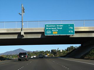 This mileage sign along California 54 east provides the distance to the next three exits: Exit 4, Woodman Street; Exit 5, Briarwood Road; and Exit 6, California 125 (South Bay Expressway) south. The mileage sign was replaced in 2007 with the opening of the southern extension of California 125; previously, the sign also included the distance to Exit 7, Jamacha Boulevard and Paradise Valley Road.