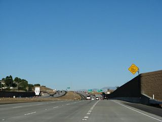 The left three lanes of California 54 (Filipino-American Highway) continue east on California 54 and connect to California 125 north to La Mesa, El Cajon, and Santee.