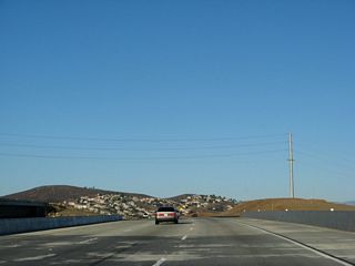 California 54 passes over the California 125 interchange. In the distance, traffic from California 125 north will merge onto California 54 east.