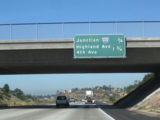 Passing under the Plaza Bonita Center Way and Reo Street overpass, this mileage sign along California 54 west provides the distance to the next two exits: Exit 2, Interstate 805 (Jacob Dekema [Inland] Freeway) and Exit 1D, Highland Avenue north and Fourth Avenue south.