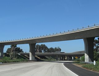 California 54 passes through the Interstate 805 interchange. The first ramp overhead connects California 54 west with Interstate 805 south. Then California 54 passes under Interstate 805's main lanes.