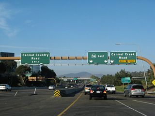 The freeway is split into express and local lanes. The June 2008 photo shows the collector distributor lanes, where eastbound California 56 approaches Exit 1, Carmel Creek Road. The December 2008 photo shows the express lanes, which have no access to Exit 1. At this point on the c/d lanes, traffic enters the freeway from El Camino Real.