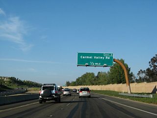 Exit 3 serves Carmel Valley Road. If a connecting road is extended south toward Del Mar Mesa, this interchange would also serve that community located to the south of the freeway. Preliminarily this road is to be called Camino Santa Fe (presumably an extension of the road of the same name in Mira Mesa), but it is doubtful this road segment would cross Los Penasquitos Canyon, and it may end up with a new name.