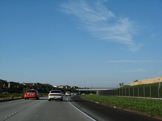 A bicycle lane parallels California 56 on the south side of the freeway. It is separated from the freeway lanes by a chain link fence. This landscaped bikeway provides a scenic yet direct route for bicyclists between Carmel Valley and Rancho Penasquitos