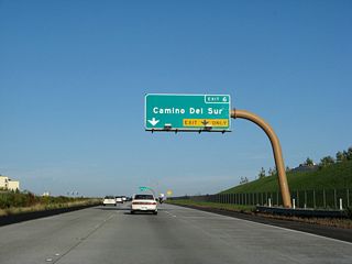 The next exit along eastbound California 56 (Ted Williams Freeway) is Exit 6, Camino del Sur. An auxiliary lane allows for a dual lane exit from the freeway. This section of freeway (from Old Carmel Valley Road to Exit 6) opened to traffic on July 19, 2004.