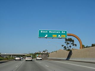 Eastbound California 56 (Ted Williams Freeway) reaches Exit 7, Black Mountain Road.
