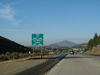 A third sign advises that traffic to Interstate 15 south and north must use the right lane, and the left two lanes will continue east onto Ted Williams Parkway toward the city of Poway.