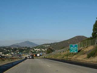 This sign is identical to the previous sign. It might be helpful to add a flashing beacon and the words "SIGNAL AHEAD" on a yellow background above these signs so that drivers at freeway speeds would slow down.