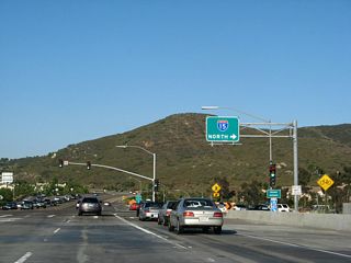 At the second traffic signal is the loop ramp to Interstate 15 north. Ted Williams Parkway continues east toward Poway from this point, and California 56 comes to an end. There is no end shield present.