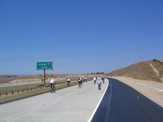 Bicyclists traveling west on California 56 toward the Carmel Valley Road interchange. The median is now full of oleander and other plants.
