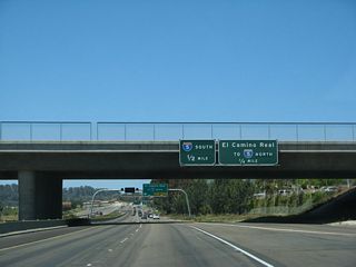 Passing under Carmel Creek Road, westbound California 56 approaches Exit 1B, El Camino Real and Carmel Valley Road west to Interstate 5 north and Exit 1A, Interstate 5 south.