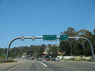 Traffic from California 56 must depart the freeway and shift onto westbound Carmel Valley Road to connect to Interstate 5 north. Turn left to follow El Camino Real south to Torrey Hills and north to Carmel Valley. Continue straight ahead on Carmel Valley Road to Del Mar Terrace and the city of Del Mar. Carmel Valley Road ultimately ends at U.S. 101/Camino del Mar.