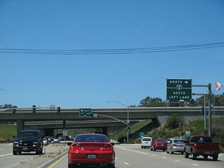 Westbound Carmel Valley Road connects to Interstate 5 north at this traffic signal. For now, this is the only connection from westbound California 56 onto northbound Interstate 5. A direct connection is planned, but it is unfunded and is locally controversial at this time. Generally speaking, residents on the west side of the freeway are not pleased at the prospect of losing several homes, while residents on the east side of the interchange want less traffic congestion through this section of Carmel Valley. Developers also want the connection completed so that several constrained properties (including several in Pacific Highlands Ranch) can be developed into houses.