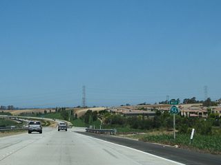 A California 56 reassurance shield is posted after the on-ramp from Camino del Sur. This section of California 56 is the longest without exits for the entire length of the freeway. At the bridge, California 56 crosses over the McGonigle Canyon; the bridge over the canyon is taller and more impressive when seen from below than when seen from the top of the bridge.