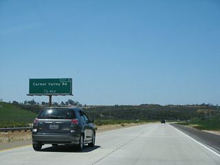 Carmel Valley Road travels north into the Pacific Highlands Ranch community of the city of San Diego. The green panel overlay covers "Camino Santa Fe," which would be the continuation south of this interchange if it is ever built.