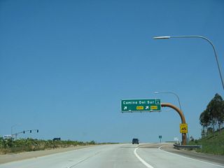 Westbound California 56 (Ted Williams Freeway) reaches Exit 6, Camino del Sur. Eventually Camino del Sur will be extended south into Park Village, pending environmental approvals. This exit also briefly served as the end of the freeway (between April 2003 and July 2004). A celebration for the opening of the segment between Black Mountain Road and Camino del Sur was presented near this interchange. Called "Play Day 56," this public ribbon-cutting event celebrated the opening of the mile-long section of California 56 freeway on April 5, 2003. That section of the 56 opened to traffic on April 11, 2003.