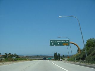 Westbound California 56 (Ted Williams Freeway) reaches Exit 7, Black Mountain Road. For several years (until April 2003), the freeway ended at this interchange.
