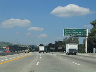 The next three exits along northbound are Exit 10, Lambert Road; Exit 11, Tonner Canyon Road; and Exit 14, Diamond Bar Boulevard in Los Angeles County. Note that this sign bridge is of a different design than those south of Exit 10; this is because the section of California 57 north through Puente Hills was constructed at a different time than the freeway south of California 90 (Imperial Highway).