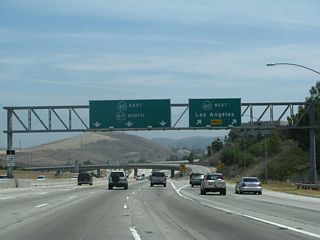 Shortly thereafter, northbound California 57 meets Exit 16, California 60 west. The pull through sign advises that the left lanes continue as California 57 north and California 60 east. The original porcelain enamel sign was replaced between 2005 and 2007; it was altered to include the direct connection for carpool traffic (left lane). Through traffic on California 57 is advised to take the main lanes rather than the carpool lanes, since the carpool lanes only connect to California 60 east (as of 2007).