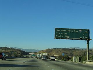 This mileage sign provides the distance to the next three exits along northbound California 57: Exit 21, Interstate 10; Exit 22, Via Verde/Raging Waters; and Exit 24A, Covina Boulevard. The latter two exits are along what used to be Interstate 210.