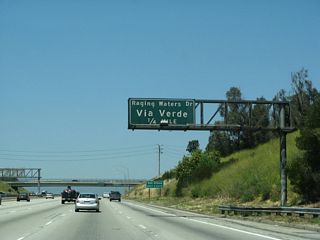 California 57 heads uphill to meet Via Verde and Raging Waters at Exit 22; afterward, the freeway begins to descend toward Exit 24A, Covina Boulevard and Exit 24B, Arrow Highway. As the name implies, Via Verde and Raging Waters provides access to the theme park Raging Waters as well as Bonelli Regional Park and Puddingstone Reservoir.