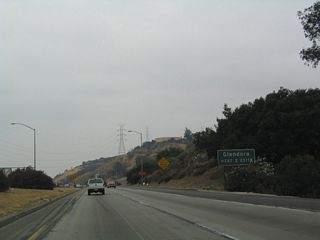 Once on the transition ramp from northbound California 57 onto westbound Interstate 210, this sign indicates that the next two exits from Interstate 210 serve the city of Glendora.