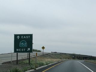 A gore point sign points the way to California 152 east to California 99 near Chowchilla and west to Los Banos and eventually Interstate 5 and Gilroy (U.S. 101).