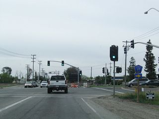 This signalized intersection along California 59 marks the southern terminus of Merced County J-7 (Santa Fe Drive). Turn right to follow J-7 northwest along Santa Fe Drive toward Winton, Ballico, Denair, Empire (California 132), Riverbank (California 108), Escalon (California 120), and Stockton (California 99). The county route extends into Stanislaus County and San Joaquin County, amounting to nearly 60 miles of signed county highway. Turn left for West Olive Avenue east.