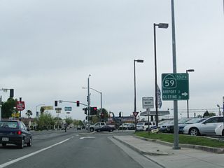 Southbound California 59 and California 99 Business split at the signalized intersection with V Street. From here, California 59 will travel southwest for a couple blocks to pass under California 99, meet California 140, and curve onto the 13th Street one-way frontage road. California 99 Business follows the old U.S. 99 corridor southeast from here into downtown Merced.