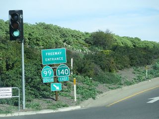 At R Street, California 140 departs from California 59 (13th Street) and merges onto the southbound California 99 freeway. California 140 and California 99 will be merged from here until Exit 186B, less than two miles southeast of here. Meanwhile, California 59 continues southeast along the 13th Street frontage road alongside the freeway.