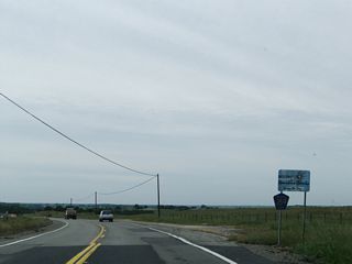 La Grange Road leaves Tuolumne County and enters Stanislaus County between Bonds Flat Road and the junction with California 132 in La Grange. This sign is posted after CR J-59 crossed over the Tuolumne River, which flows away from the Don Pedro reservoir. Although not shown here, an old alignment of CR J-59 (now known as Old La Grange Road) travels east of the existing alignment of CR J-59. It crosses the Tuolumne River on a through-truss bridge that is no longer open to traffic.