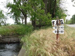 Nearby is an older, porcelain-enamel federal aid secondary marker. This type of signage is now considered obsolete and is increasingly difficult to find in California.